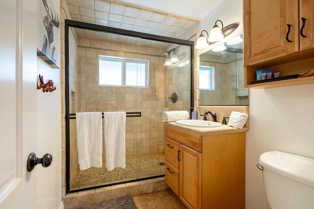 bathroom featuring vanity, toilet, tile patterned flooring, and an enclosed shower