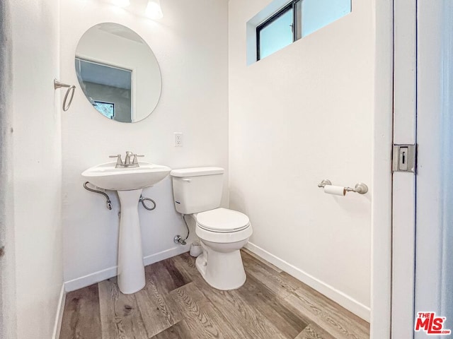 bathroom featuring wood-type flooring and toilet