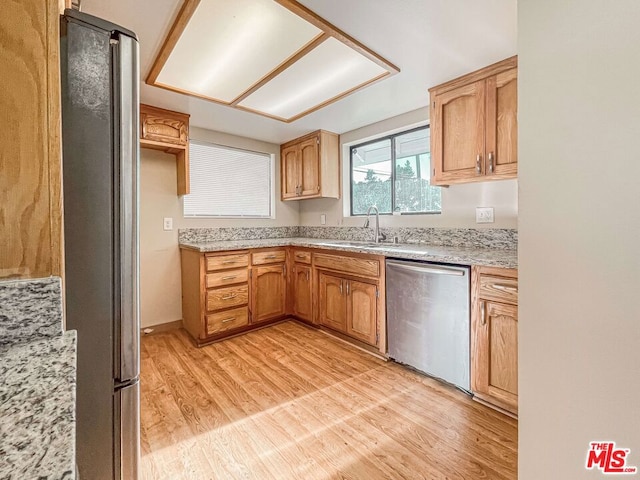 kitchen featuring appliances with stainless steel finishes, sink, and light hardwood / wood-style floors