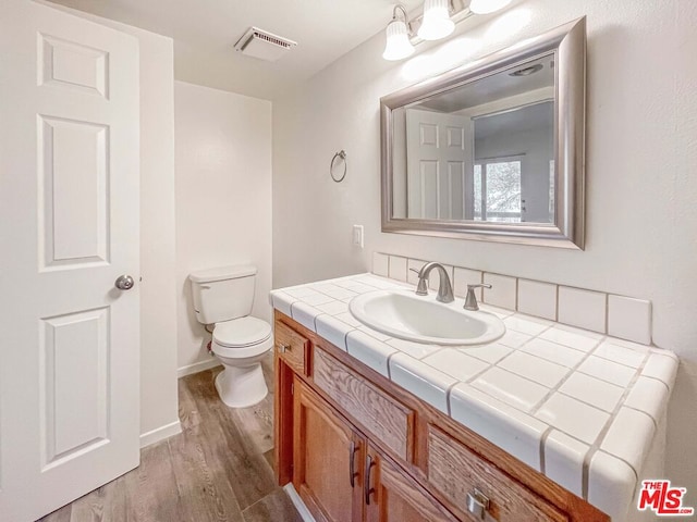 bathroom featuring hardwood / wood-style floors, toilet, and vanity