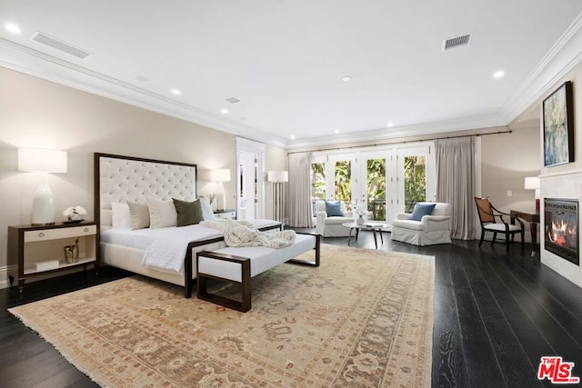 bedroom featuring dark hardwood / wood-style flooring, ornamental molding, french doors, and a fireplace