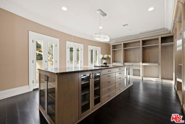 spacious closet with french doors, dark hardwood / wood-style flooring, and an inviting chandelier