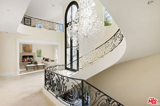 stairway featuring an inviting chandelier and a high ceiling