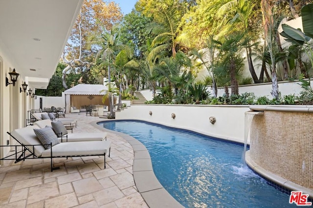 view of pool with pool water feature, a gazebo, and a patio