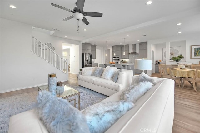 living room featuring light hardwood / wood-style floors and ceiling fan