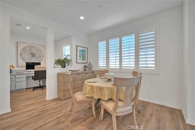 dining space featuring light hardwood / wood-style floors and built in desk