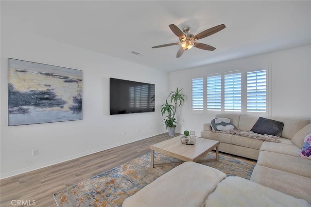 living room featuring ceiling fan and light hardwood / wood-style floors