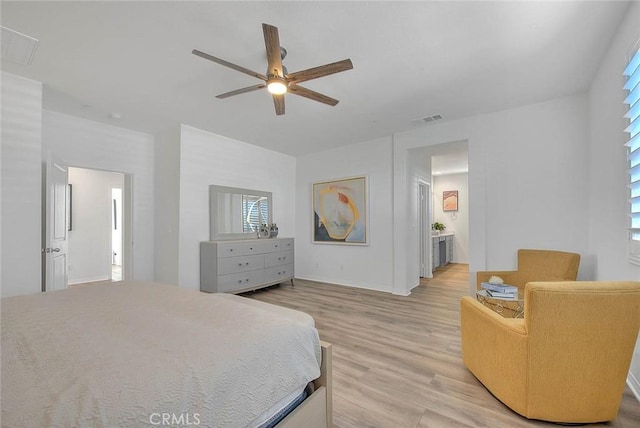 bedroom featuring ceiling fan, light hardwood / wood-style flooring, and ensuite bath