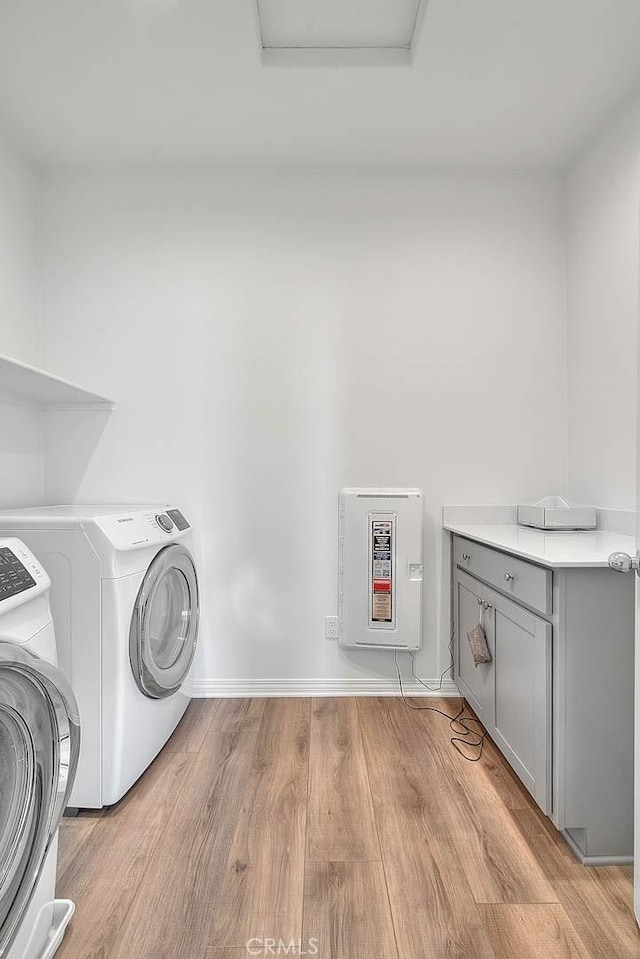 washroom featuring washer and dryer, light hardwood / wood-style floors, and heating unit