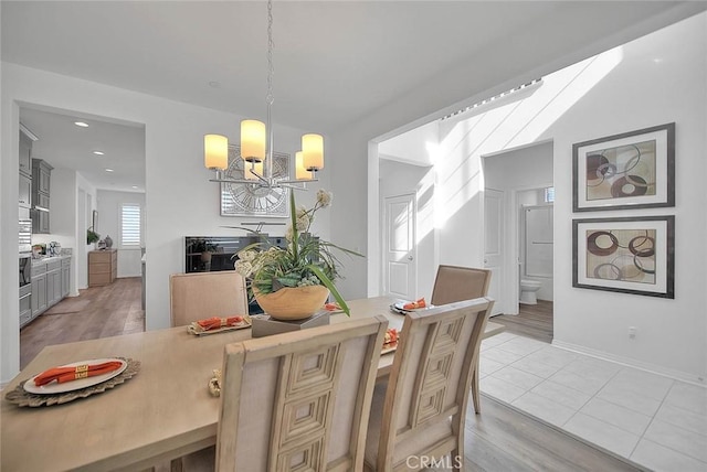 dining area with light wood-type flooring and a chandelier