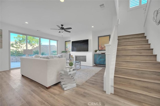 living room with light hardwood / wood-style floors and ceiling fan