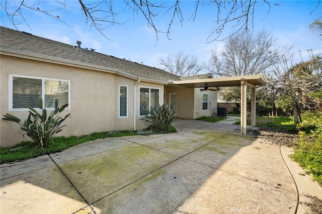 rear view of property featuring ceiling fan, central air condition unit, and a patio area