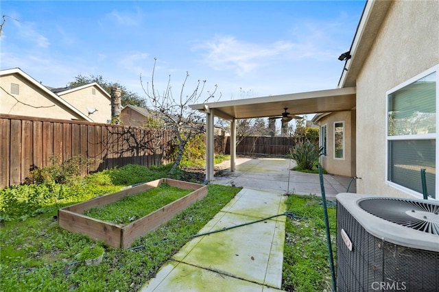 view of yard with ceiling fan, central air condition unit, and a patio