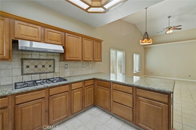 kitchen featuring kitchen peninsula, vaulted ceiling, wall chimney range hood, and decorative backsplash