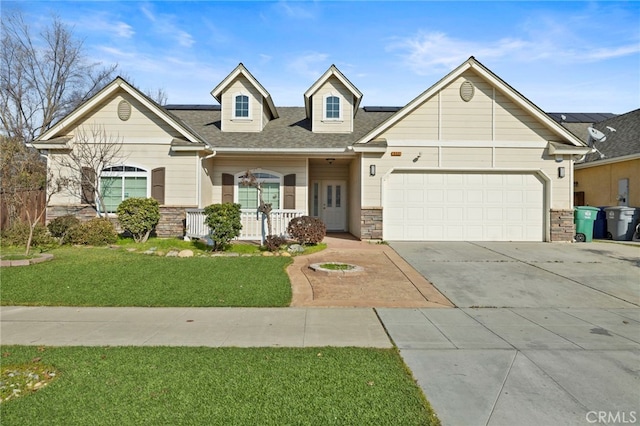 view of front of home featuring a garage, a front yard, and covered porch