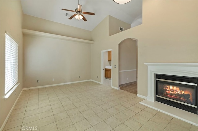 unfurnished living room featuring ceiling fan, high vaulted ceiling, and light tile patterned flooring