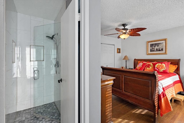 bedroom featuring hardwood / wood-style flooring, a textured ceiling, and ceiling fan