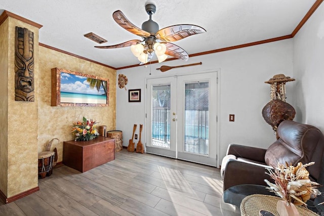 living area featuring wood finished floors, french doors, and ornamental molding