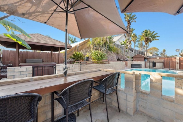 view of pool featuring outdoor dry bar, a patio area, a fenced in pool, and a fenced backyard