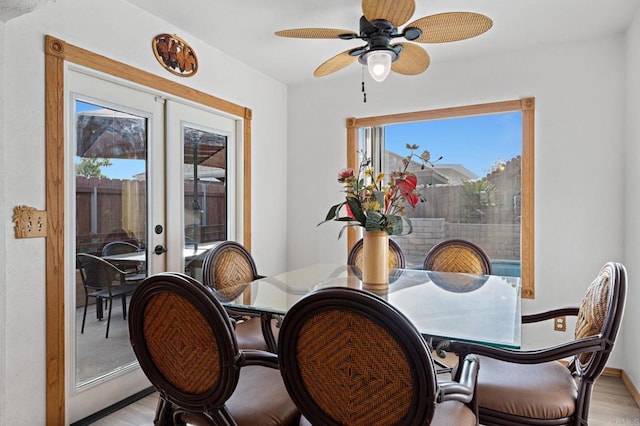 dining area with ceiling fan, french doors, baseboards, and light wood-style flooring