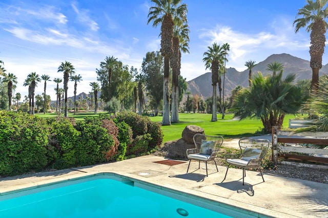 view of pool featuring a mountain view, a yard, and a patio