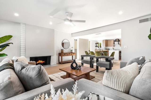 living room featuring ceiling fan and light hardwood / wood-style flooring