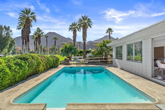 view of swimming pool with a mountain view and a patio