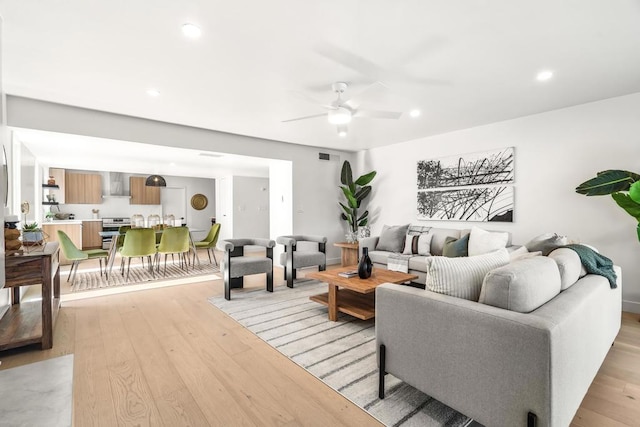 living room featuring ceiling fan and light hardwood / wood-style flooring