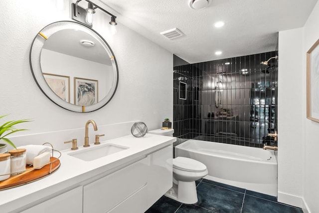 full bathroom with toilet, tiled shower / bath combo, tile patterned floors, a textured ceiling, and vanity