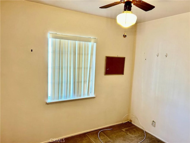 carpeted spare room featuring ceiling fan