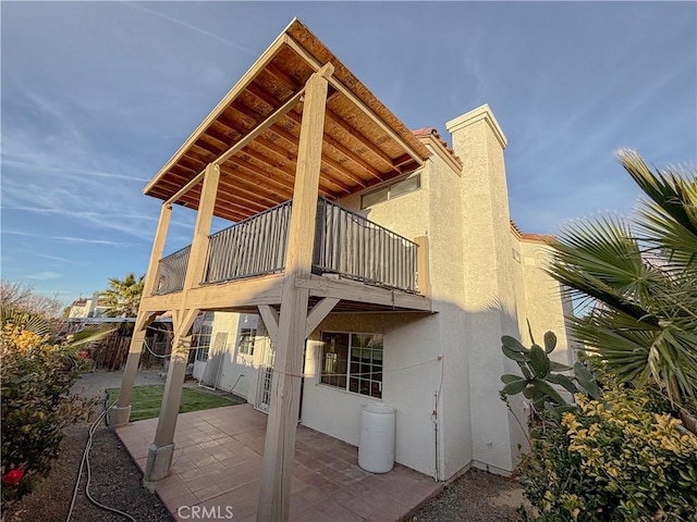 rear view of house featuring a patio area and a balcony