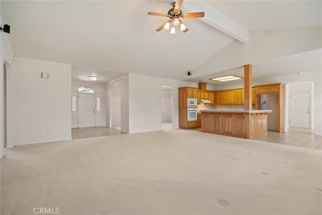 unfurnished living room featuring light carpet, ceiling fan, and lofted ceiling with beams