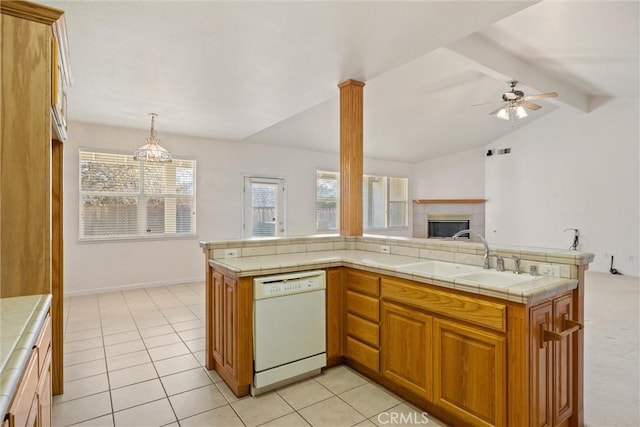 kitchen featuring dishwasher, ceiling fan with notable chandelier, tile countertops, and pendant lighting