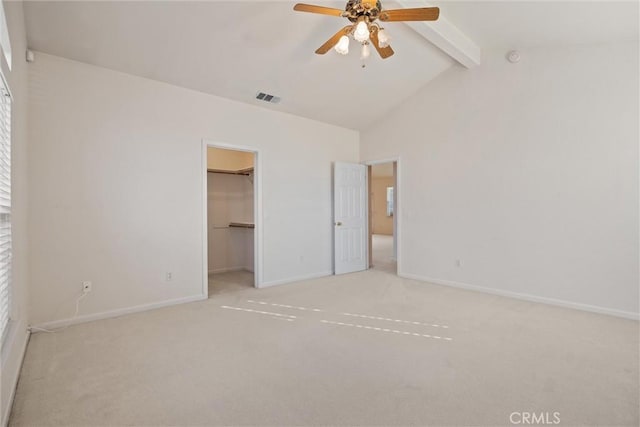 unfurnished bedroom with ceiling fan, a walk in closet, a closet, and light colored carpet