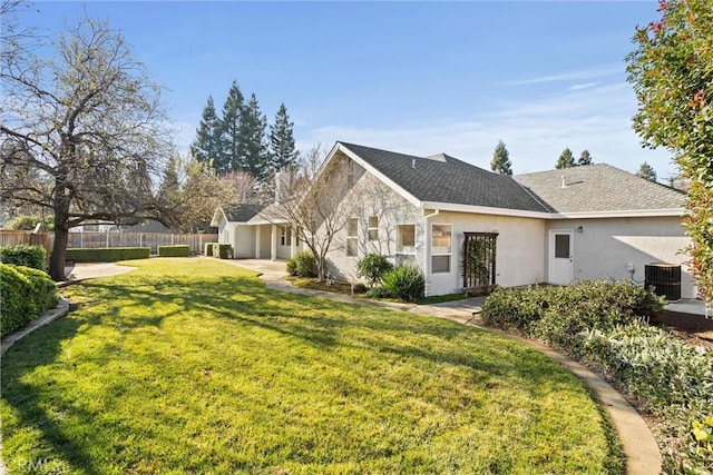 back of house with central AC unit and a lawn