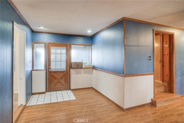 foyer with ornamental molding and light hardwood / wood-style floors