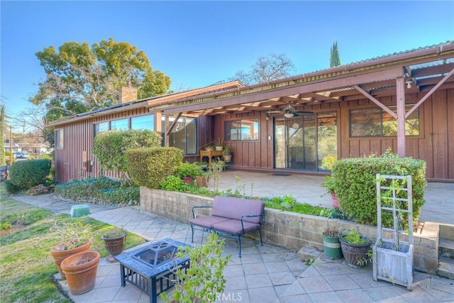 view of patio with ceiling fan and a fire pit