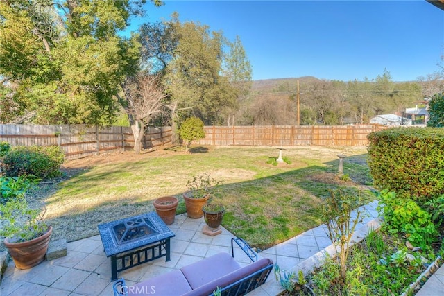 view of yard featuring an outdoor fire pit, a fenced backyard, and a patio