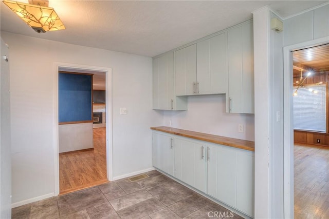 kitchen with butcher block counters and white cabinets