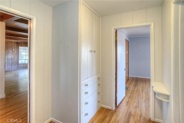 corridor featuring light hardwood / wood-style flooring and wood walls