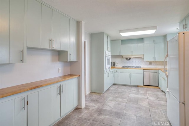 kitchen featuring white cabinets, wooden counters, and stainless steel appliances