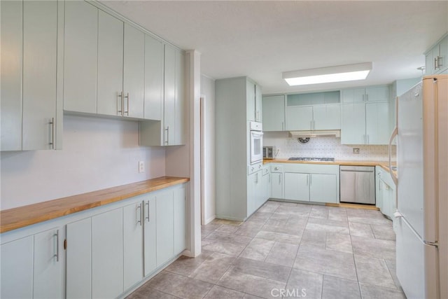 kitchen featuring wood counters, appliances with stainless steel finishes, and white cabinets