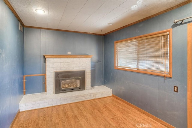 unfurnished living room featuring a brick fireplace, light hardwood / wood-style flooring, and crown molding