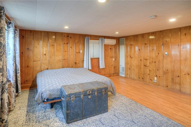 bedroom with an AC wall unit and wood walls