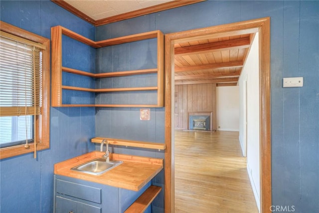 kitchen with wooden ceiling, sink, blue cabinets, and a healthy amount of sunlight