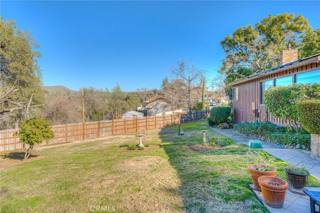 view of yard with a fenced backyard and a mountain view