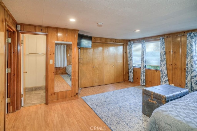 bedroom featuring light hardwood / wood-style floors and wood walls