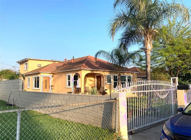 mediterranean / spanish-style house featuring a fenced front yard and stucco siding