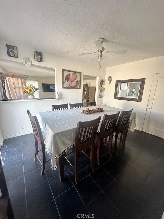 dining room featuring a textured ceiling, a ceiling fan, and baseboards