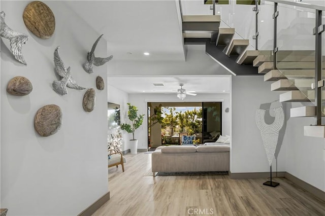 living room featuring wood-type flooring and ceiling fan